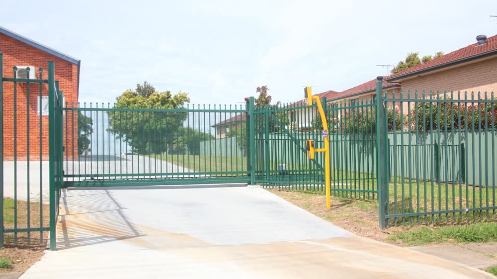 Green cantilever security gate with integrated access control installed at a Sydney school.